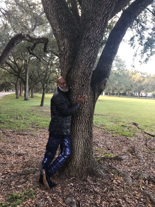 a picture of moyo okediji hugging a tree