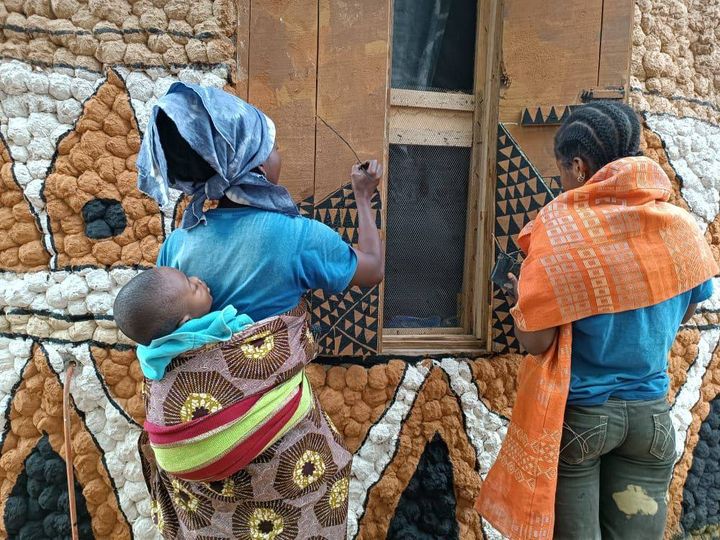 a post by moyo okediji showing the akodi orisa artists working on a window frame