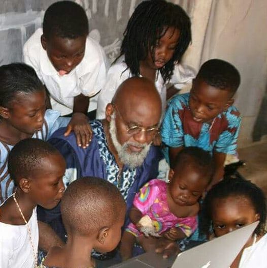 a picture showing moyo okediji and soem kids working on a computer
