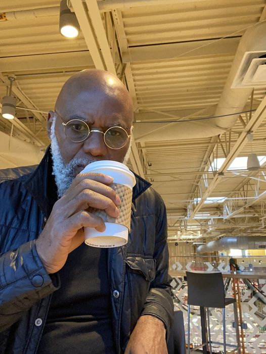 a picture showing moyo okediji sitting and taking a sip of his starbuck